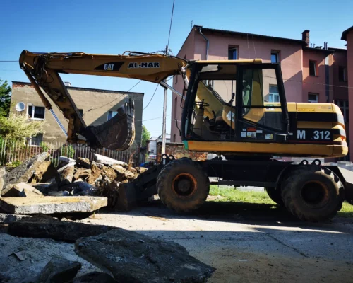 Koparka kołowa do robót ziemnych i wykopów w terenie miejskim Głubczyc.